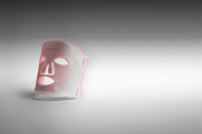 Express by Déesse PRO held to the face, red LEDs glowing