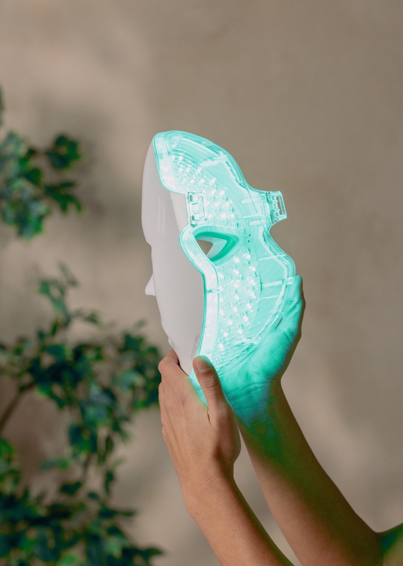 PRO by Déesse PRO mask held up, green LEDs glowing